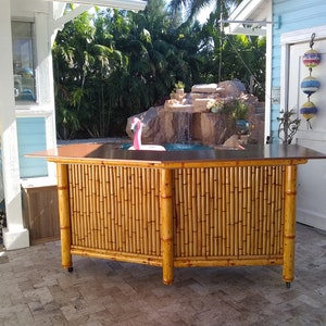 Bamboo tiki bar with storage cabinets, electrical outlets, Led lights, and drink counter. Optional mini fridge, tiki masks, wheels & epoxy.