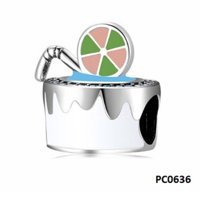 May include: Silver charm with a white and blue enamel design of a glass with a lime wedge and a straw. The charm has a small hole for attaching to a bracelet or necklace. PC0636