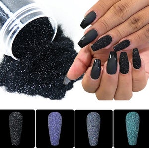 Puede incluir: Esmalte de uñas de purpurina negro, azul y verde. La purpurina es fina y crea un efecto brillante en las uñas. La purpurina se muestra en un frasco pequeño y en las uñas de una persona.