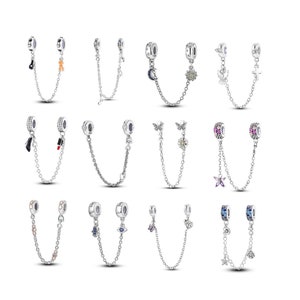 May include: Twelve silver charm bracelet extender chains with various charms, including a butterfly, a star, a moon, a heart, a flower, a shoe, a lipstick, and a cross.