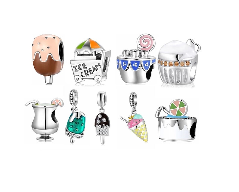 May include: A set of nine silver charm beads with various ice cream and dessert designs. The charms feature colorful enamel and glitter accents. The charms include an ice cream cone, a popsicle, a cupcake, an ice cream cart, a cocktail glass, and a cake.