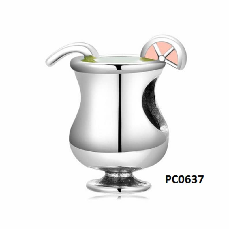 May include: Silver charm in the shape of a cocktail glass with a lime wedge and a straw. The glass is filled with a green liquid. The charm has a hole for attaching to a bracelet. PC0637