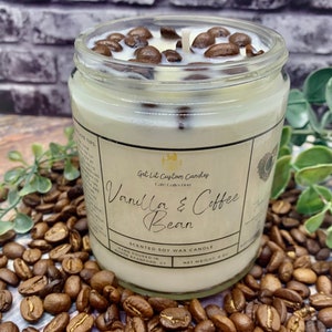 May include: A glass jar candle with a white label that reads "Get Lit Custom Candles" and "Vanilla & Coffee Bean". The candle is surrounded by coffee beans.