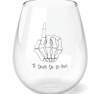 Puede incluir: Una copa de vino de vidrio transparente con una mano de esqueleto sosteniendo un anillo. El texto "Til Death Do Us Part" está impreso en el vidrio.