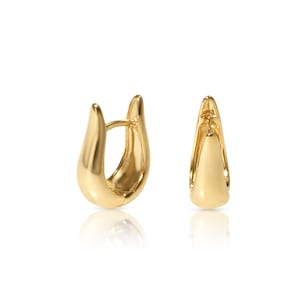 Puede incluir: Un par de pendientes de aro de oro con un diseño liso y redondeado. Los pendientes están hechos de un metal brillante y tienen un estilo simple y elegante.