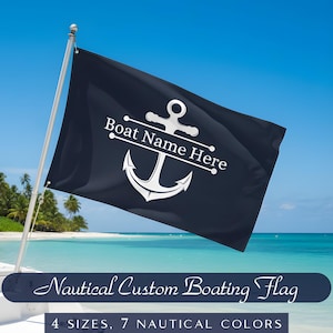May include: A navy blue nautical flag with a white anchor design and the text "Boat Name Here." The flag is displayed on a boat with a tropical beach and blue sky in the background. The text "Nautical Custom Boating Flag" is at the bottom.