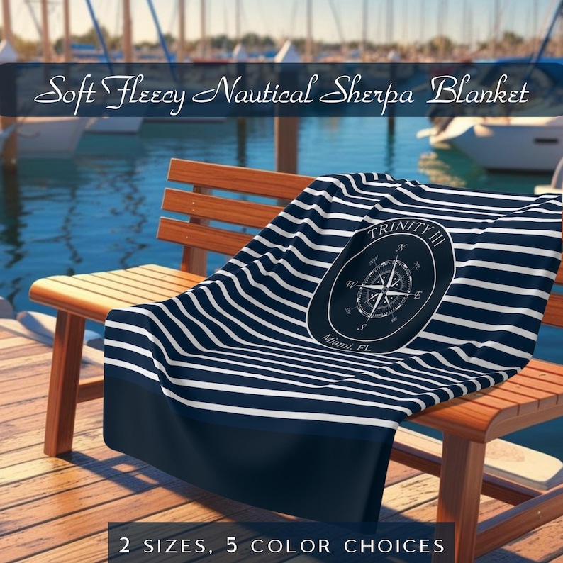 May include: A navy and white striped nautical sherpa blanket with a compass rose design. The blanket is draped over a wooden bench near a body of water. Text on the blanket reads "TRINITY III Miami, FL". The image also includes the text "Soft Fleecy Nautical Sherpa Blanket".