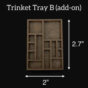 May include: A wooden trinket tray with multiple compartments, measuring 2 inches wide and 2.7 inches tall. The tray is a dark brown color and has a rectangular shape with various sized square and rectangular compartments.
