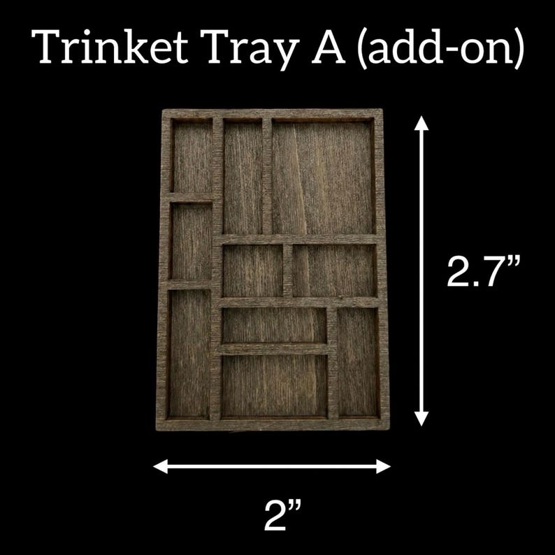 May include: Wooden trinket tray with multiple compartments. The tray is 2 inches wide and 2.7 inches tall. The text "Trinket Tray A (add-on)" is at the top. The tray is made of wood and has a dark brown color.