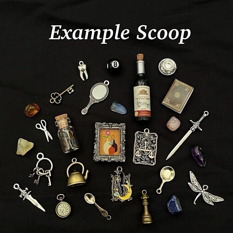 May include: A collection of miniature charms and trinkets, including a tiny wine bottle, a mirror, a sword, and a framed picture. The items are arranged on a black surface, with the text "Example Scoop" at the top.