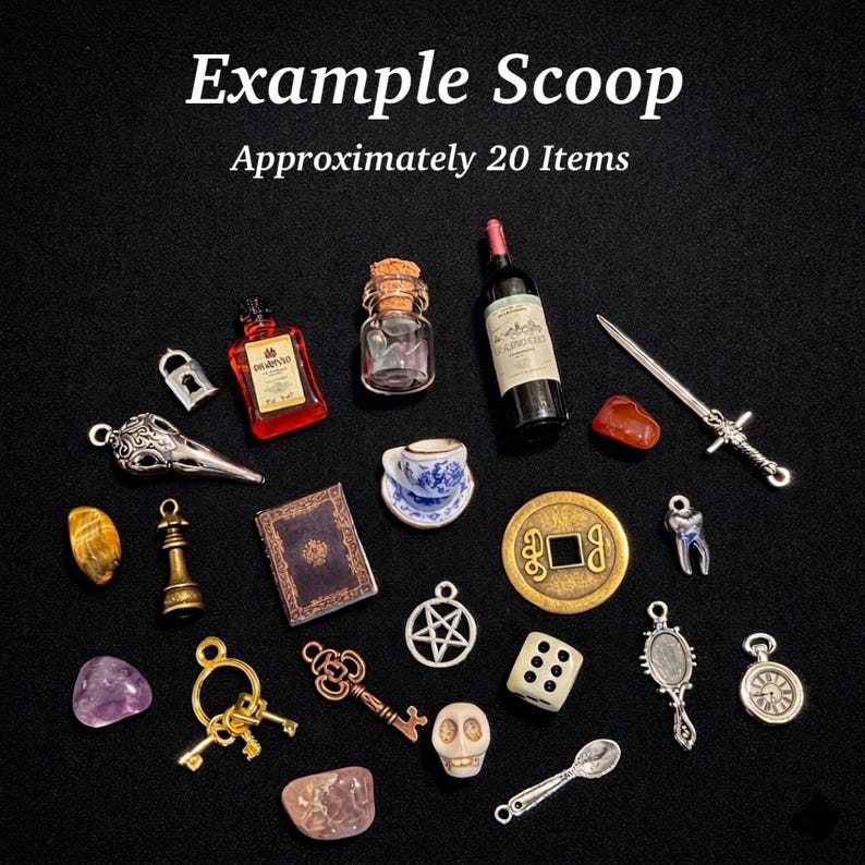 May include: A collection of approximately 20 miniature charms and trinkets including a red bottle, a glass jar with a cork, a wine bottle, a silver sword, a blue and white teacup, a book, a gold coin, a die, a skull, and various metal keys.