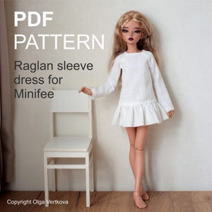 May include: A white raglan sleeve dress for a Minifee doll. The dress has long sleeves and a ruffled skirt. The text "PDF PATTERN" and "Copyright Olga Vertkova" are visible in the image.