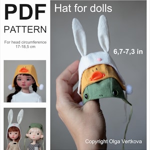 May include: A stack of three doll hats: a white bunny hat, a yellow duck hat, and a green frog hat. The hats are held in a hand and are approximately 6.7 to 7.3 inches in size. The image also includes a PDF pattern for the hats, designed for a head circumference of 17-18.5 cm.