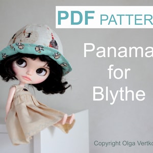 May include: PDF pattern for a Panama hat for Blythe dolls. The hat is teal blue with a white and brown print of monkeys and houses. The pattern is by Olga Vertkova.