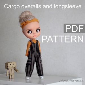 May include: PDF pattern for cargo overalls and long sleeve shirt for a doll. The doll is wearing black and white striped overalls with a mustard yellow long sleeve shirt. The doll has blonde hair and brown eyes. The text "PDF PATTERN" is in the upper right corner of the image.