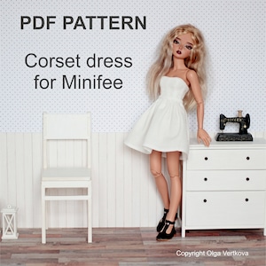 Peut inclure: Patron PDF pour une robe corset blanche pour poupée. La poupée porte la robe et se tient à côté d'une chaise blanche et d'une commode blanche. Le texte "PDF PATTERN" et "Corset dress for Minifee" est visible sur l'image.