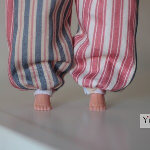 May include: A pair of striped pants with one leg blue and white and the other leg pink and white. The pants are made of a soft, cotton fabric and have a relaxed fit.
