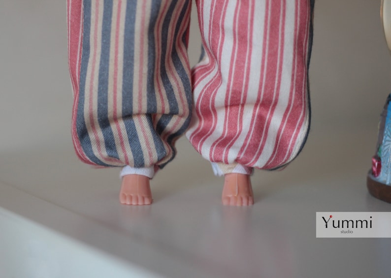 May include: A pair of striped pants with one leg blue and white and the other leg pink and white. The pants are made of a soft, cotton fabric and have a relaxed fit.