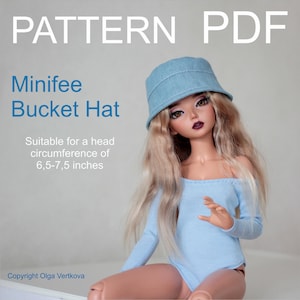 Peut inclure: Un chapeau bob en jean bleu clair, adapté à un tour de tête de 16,5 à 19,1 cm. L'image affiche le texte "PATTERN PDF" et "Minifee Bucket Hat". La poupée porte un haut bleu clair à épaules dénudées.