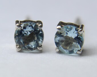 May include: A pair of silver stud earrings with light blue aquamarine gemstones.