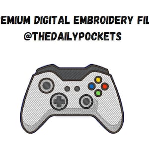 Puede incluir: Un mando de videojuegos blanco con botones negros y una superficie gris texturizada. El mando tiene un botón verde, amarillo, rojo y azul en la parte superior derecha. El texto "@THEDAILYPOCKETS" está por encima del mando.