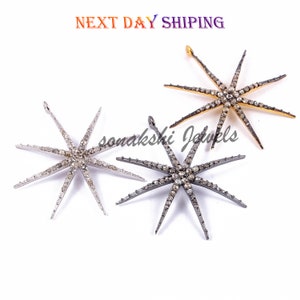 May include: Three silver, gold, and black star-shaped pendants with a diamond-like design. Each pendant has eight points and is adorned with small, sparkling stones.