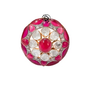 Pode incluir: Um anel redondo em tom dourado com um design floral rosa e branco. O centro do anel apresenta uma pedra grande, redonda e rosa cercada por pedras brancas menores. O anel é engastado em um metal de tom dourado.