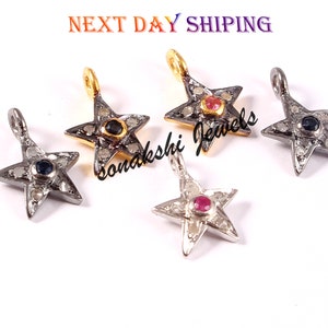May include: Five silver star-shaped pendants with a small gemstone in the center. The gemstones are blue, red, and pink. The pendants are surrounded by smaller white gemstones.