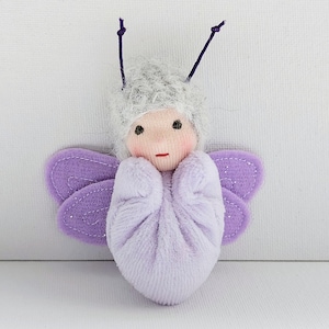 May include: A white ceramic mug with a black handle and the text "But First, Coffee" in a handwritten style. The mug is on a white surface. The mug is 10 cm tall.