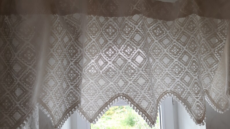 May include: White crocheted valance with a diamond pattern and scalloped edges. The valance has a delicate, lacy look and would add a touch of elegance to any window.