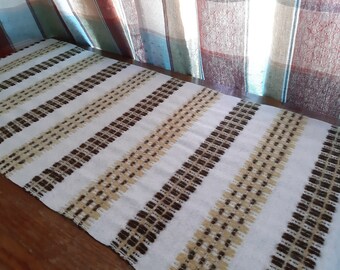 May include: White table runner with brown and beige stripes. The stripes are woven with a textured pattern.