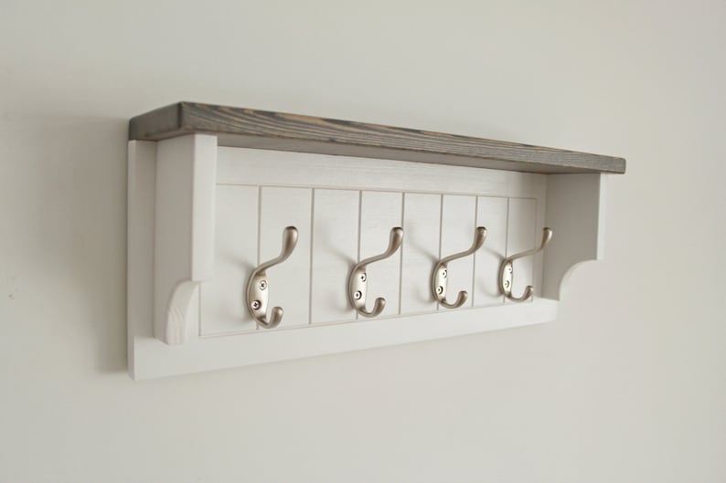 May include: White wooden coat rack with a gray stained top shelf and five silver hooks.