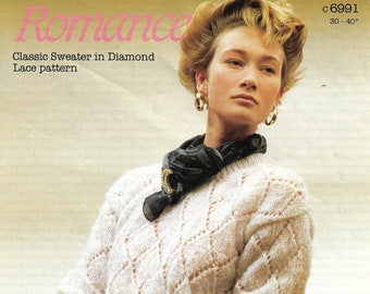 May include: A white sweater with a diamond lace pattern. The sweater is knit and has a crew neck. The model is wearing a black scarf and gold earrings. The text "Romance" and "Classic Sweater in Diamond Lace pattern" is printed on the image. The text "c 6991 30-40" is also printed on the image.