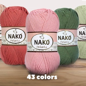 Puede incluir: Cinco ovillos de hilo Nako Pırlanta en varios colores: beige, coral, rosa, verde y verde claro. Cada ovillo tiene una etiqueta con el nombre de la marca. El texto "43 colores" se muestra en la parte inferior, indicando la gama de colores disponibles.