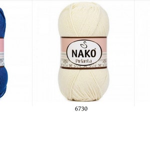 Puede incluir: Tres ovillos de hilo Nako Pırlanta. Uno es azul oscuro, los otros dos son blanquecinos. Cada ovillo tiene una etiqueta con el nombre de la marca y un c&oacute;digo de producto. El ovillo azul est&aacute; etiquetado como 5329, y los ovillos blanquecinos est&aacute;n etiquetados como 6730 y 300.