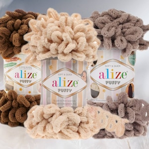 May include: A selection of Alize Puffy yarn in shades of brown, beige, and taupe. The yarn is presented in cylindrical containers, with the brand name and product information visible. The image highlights the soft and quick characteristics of the yarn.