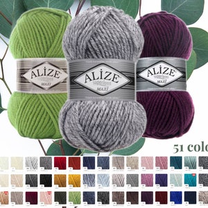 May include: Three skeins of Alize Superlana Maxi yarn in green, gray, and deep purple. Each skein is labeled with the brand name. A color chart displays 51 available yarn colors, offering a wide range of options for knitting and crochet projects.