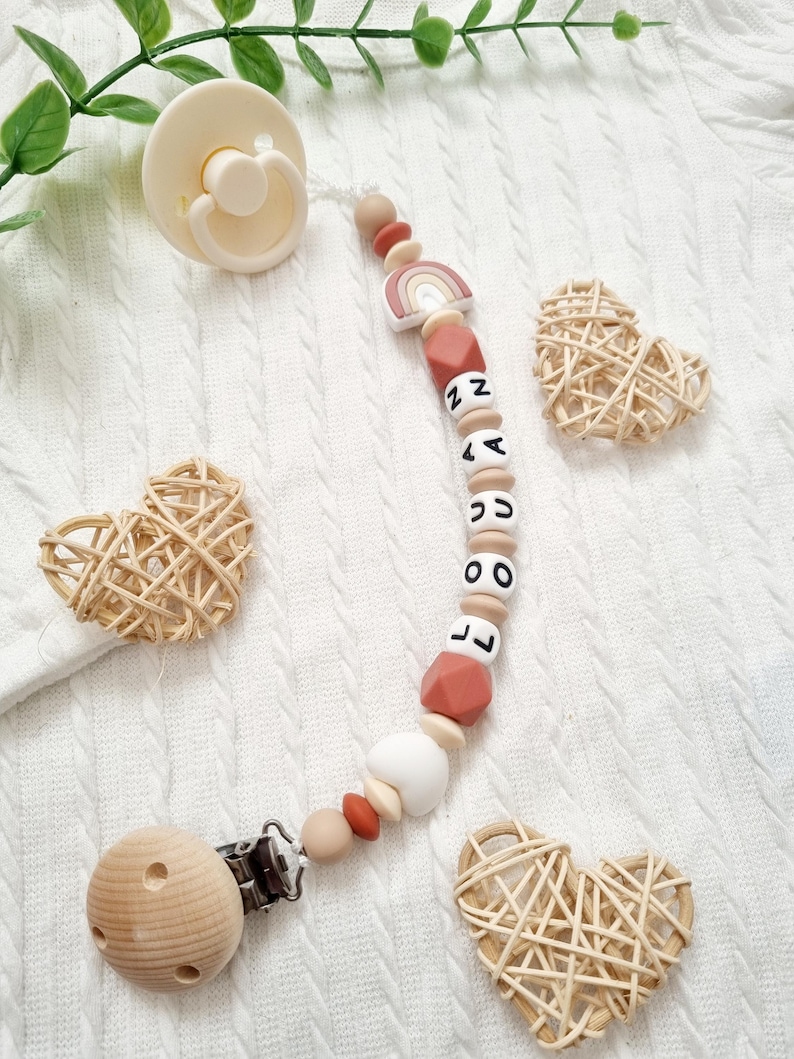 Attache tétine personnalisée arc en ciel et coeur avec perles en silicone  terracotta et beige – clip en bois naturel - création artisanale Leonoecreations.