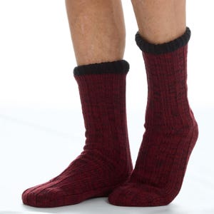 May include: A pair of mid-calf socks featuring a deep burgundy and black marled knit pattern. The socks are constructed with a ribbed texture throughout the leg and foot, finished with a solid black ribbed cuff at the top opening.