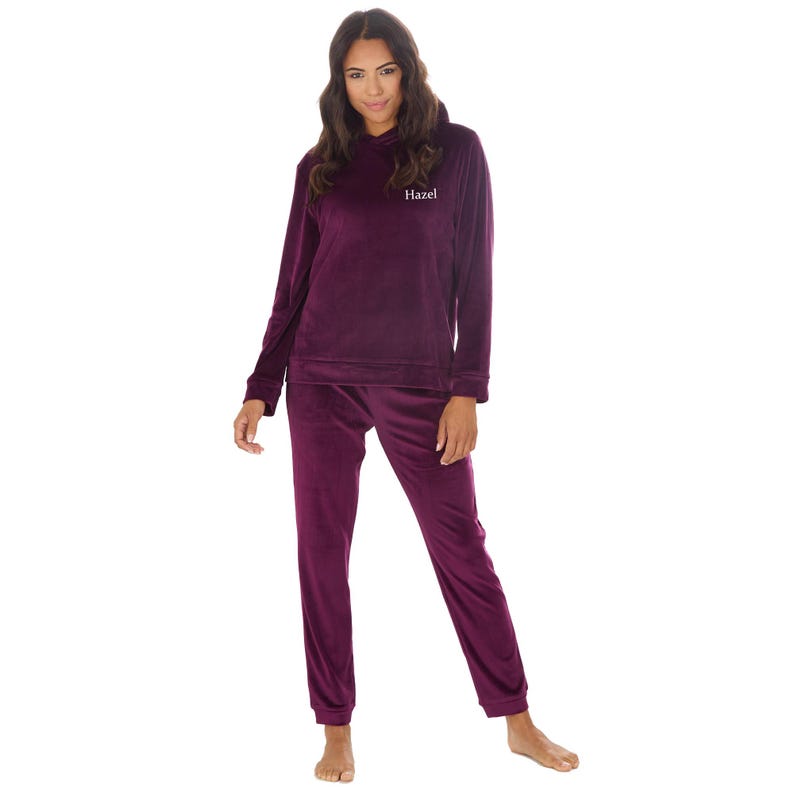 May include: Burgundy velour hooded pajama set with the name "Hazel" embroidered on the front.