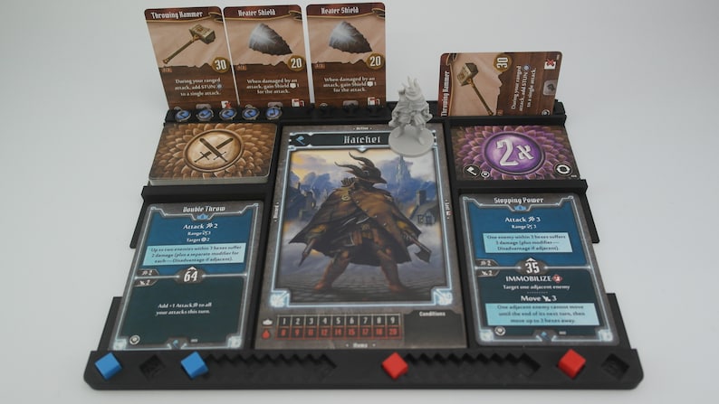 May include: A tabletop game setup with a character card for "Hatchet" and a miniature figure. The character card has a health tracker and a list of conditions. The player has a variety of cards in their hand, including "Double Throw", "Throwing Hammer", "Razor Shield", and "Stepping Point".