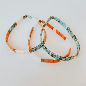 Stack of 3 Tila bead bracelets made of colorful square glass beads and elastic.
