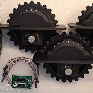 May include: Three black rotary encoders with digital displays and a green circuit board. The encoders are connected to a black USB cable labeled "USB AMMUNI B 5 PIN 10 FT".