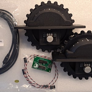 May include: Three black rotary encoders with a green circuit board and a black USB cable. The encoders have a black plastic housing with a white dial and a black knob. The circuit board has a white label with the text "USB AMM/NI B 5 PIN 10 FT".