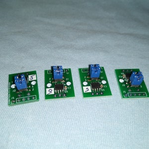 May include: Four green circuit boards with blue connectors and black components. The boards are labeled with numbers 5 and 9.