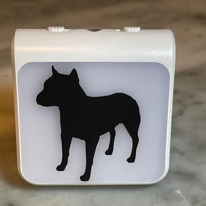 May include: White night light with a black silhouette of a dog on the front.