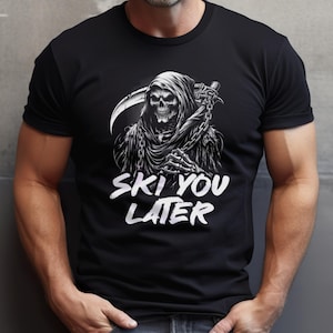 May include: A black short-sleeved t-shirt featuring a white graphic of a hooded grim reaper figure holding a scythe and chains. Below the illustration, the text reads "SKI YOU LATER" in a bold, white, distressed-style font across the chest.