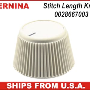 May include: A cream-colored Bernina stitch length knob with a ridged, conical design. The knob has a white top with a black line indicator. The text "Stitch Length Knob 0028667003" is above the knob.