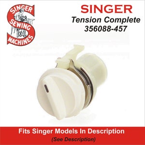 May include: A Singer sewing machine tension complete assembly. The part is off-white with a metal ring and a lever. The text "SINGER" and "Tension Complete 356088-457" are visible. The image also includes the text "Fits Singer Models In Description".