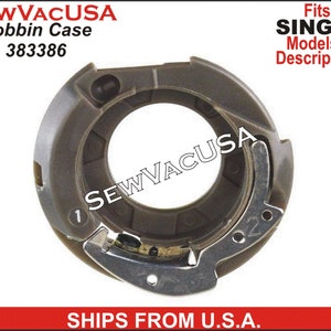 May include: A dark gray bobbin case for Singer sewing machines. The case has a circular design with a metal latch and the number "1" and "2" marked on the surface. The text "SEWVACUSA" and "Bobbin Case 383386" are also visible.